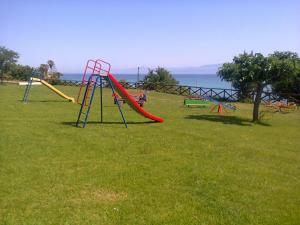 a group of playground equipment in a grass field at Fruit Village Tropea Baia della Rocchetta Soft all Inclusive in Conidoni