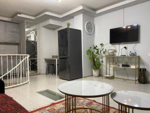 a living room with two tables and a refrigerator at Behind the Parliament Building in Tbilisi City