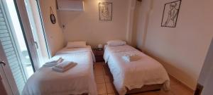 two twin beds in a room with a window at Harmony 3 in Artemida +35 photos