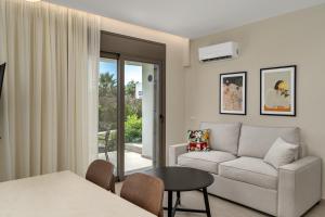 a living room with a couch and a table at Palm View Suites in Kourouta +43 photos