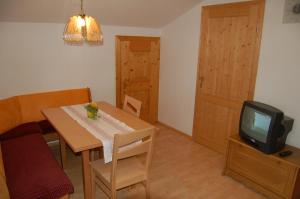 a dining room with a table and a tv at Großberghof in Taxenbach