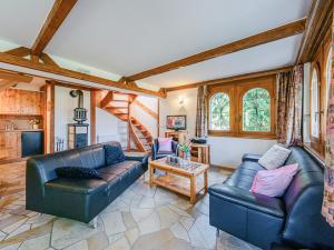 a living room with two leather couches and a table at Chalet Marinette in Icogne