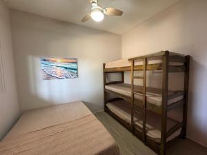 a bedroom with two bunk beds and a ceiling fan at Caminho do mar in Itanhaém