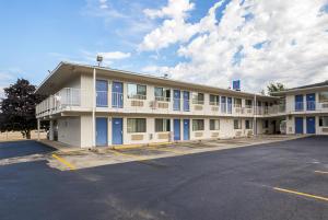 um grande edifício com janelas azuis e um parque de estacionamento em Motel 6-Rochester, MN em Rochester