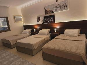a hotel room with two beds and two lamps at شقة العقيق الأولى in Medina