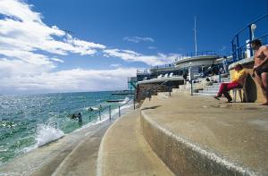 two people sitting on a pier looking at the ocean at Beachside 1 in Saint Helier Jersey