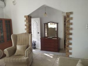a living room with a chair and a mirror at Spiti Lou in Nótos