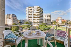 a balcony with a table and chairs and a view of a city at LOS RESPIGOS PLAYA in Laredo