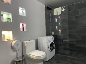 a bathroom with a toilet and a washing machine at Behind the Parliament Building in Tbilisi City +6 photos