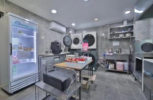 a kitchen with a table and a refrigerator at Hotel Advance Jeonju in Jeonju