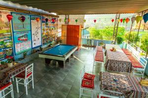 a pool table in a room with tables and chairs at Phong Nha Cherish House in Phong Nha