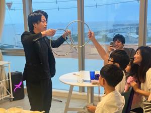 a man holding a hula hoop in front of a group of people at MARSOL CS Beach Hotel in Chigasaki +144 photos