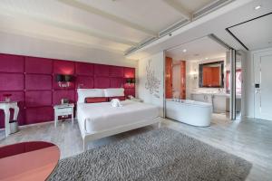 a bedroom with a large white bed and a tub at Hua Chang Heritage Hotel in Bangkok +53 photos