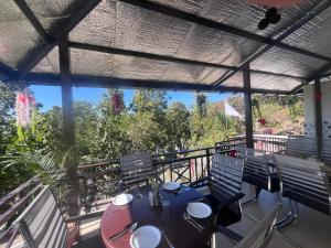 a patio with a table and chairs on a balcony at Navya Homestay and Restaurant in Jāmb
