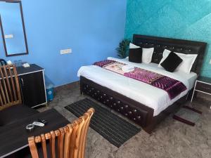 a bedroom with a large bed and a blue wall at Navya Homestay and Restaurant in Jāmb