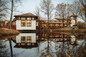 a house is reflected in a body of water at Schlafgut am Johanneshof in Tattendorf