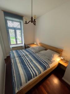 a bedroom with a bed with a blue and white striped blanket at Bastians Herberge in Leipzig