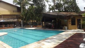 a swimming pool in front of a house at Amarilis Flat Apartament in Riviera de São Lourenço