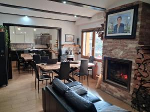 a living room with a fireplace and a table and chairs at B&B Didova in Gavoi