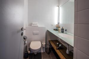 a white bathroom with a toilet and a sink at Hotel Kolding in Kolding +50 photos