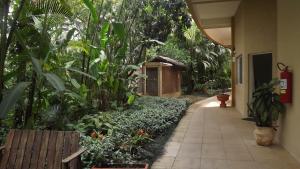 a walkway in a garden next to a building at Amarilis Flat Apartament in Riviera de São Lourenço