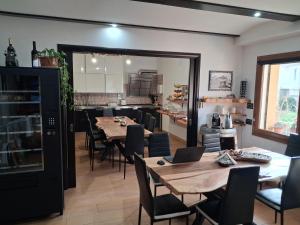 a dining room with tables and chairs and a kitchen at B&B Didova in Gavoi