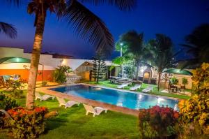 a villa with a swimming pool at night at Residenza Canoa in Canoa Quebrada