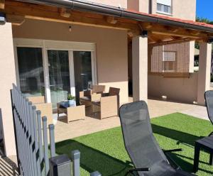 a patio with chairs and tables on a lawn at Zelena oaza in Krk