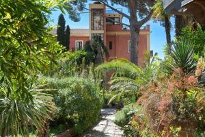 a garden in front of a house with plants at GARDEN VILLA SUITE - Hotel Villa Schuler in Taormina +17 photos