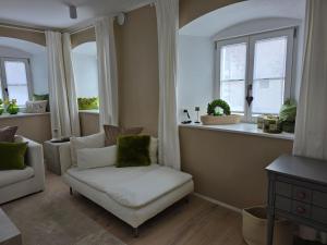 a living room with a chair and two windows at Kavaliershaus Wallerstein, stilvolle Wohnung mit Privatparkplatz in Wallerstein
