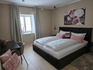 a bedroom with a large bed with pink and white pillows at Kavaliershaus Wallerstein, stilvolle Wohnung mit Privatparkplatz in Wallerstein +28 photos