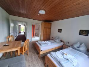 a room with two beds and a wooden ceiling at Pension Sochor in Aidenbach