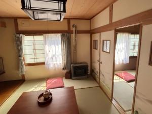 a living room with a table and a television at Hi Song Villa in Otaru