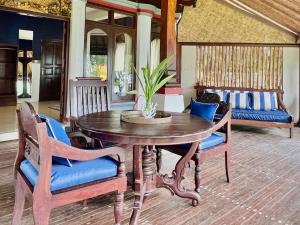 a wooden table with chairs and a potted plant at The Palms - Seraya Shores Retreat Bali in Seraya +84 photos