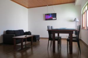 a living room with a table and a couch at Apartamento Segundo Canto in Ponta Delgada