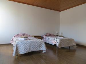 a room with two beds and two tables in it at Apartamento Segundo Canto in Ponta Delgada