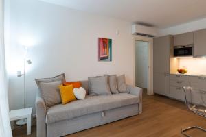 a living room with a gray couch with colorful pillows at Nolo Town Luxury Place in Milan