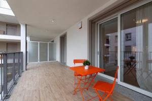 an empty balcony with a red table and chairs at Nolo Town Luxury Place in Milan
