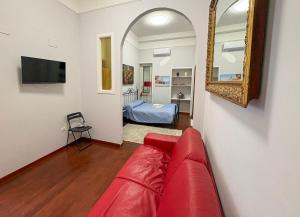 a living room with a red couch and a mirror at Milion's House Apartments in Salerno