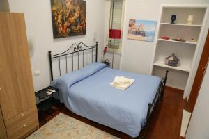 a small bedroom with a bed with a blue blanket at Milion's House Apartments in Salerno