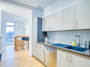 a kitchen with white cabinets and a blue sink at Grand appartement avec jacuzzi et jardin in Clermont-Ferrand
