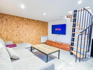 a living room with a couch and a table at Grand appartement avec jacuzzi et jardin in Clermont-Ferrand