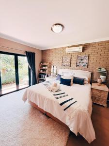 a bedroom with a large bed and a brick wall at Peach Blossom Guesthouse in Welkom