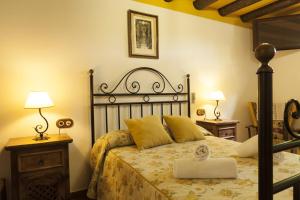 a bedroom with a bed with yellow pillows at Cortijo La Algallumbilla in Carcabuey
