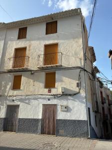 a white building with windows and a balcony at Casa del Puente in Nerpio