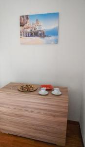 a counter with two cups and a pizza on it at Milion's House Apartments in Salerno