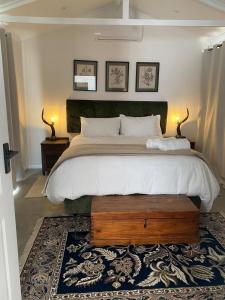 a bedroom with a large bed and two lamps at Desert Bloom Cottage in Buffelskloof +35 photos