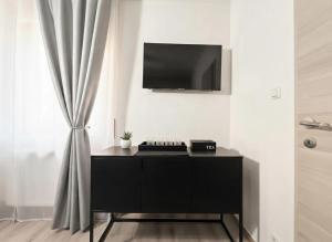 a black cabinet with a flat screen tv on a wall at Zemlinsky Loft Bunk Room in Payerbach