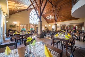 a restaurant with wooden ceilings and tables and chairs at Wellness hotel Spark in Malacky
