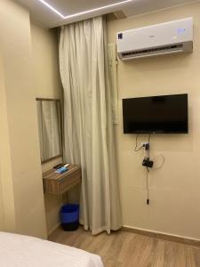 a bedroom with a bed and a television on the wall at Crown pyramids hotel in Cairo